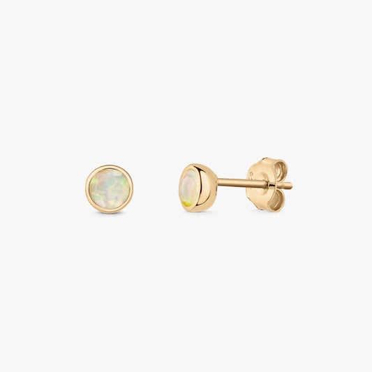 Pair of gold-plated sterling silver opal birthstone stud earrings shown front and side on a white background, round bezel-set stones with butterfly backs.