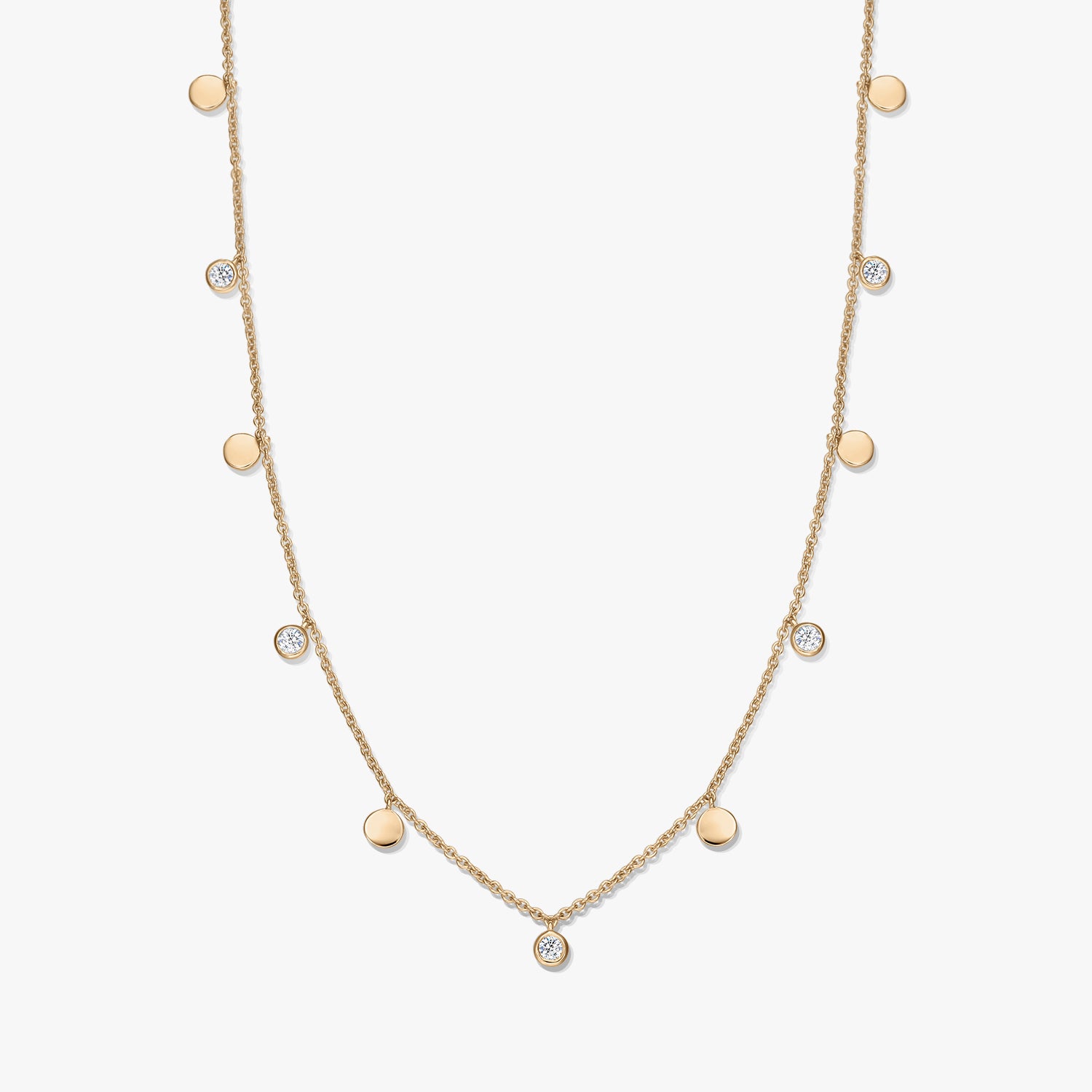 Gold‑plated sterling silver station necklace with alternating small polished disc charms and bezel‑set white topaz on a delicate chain, photographed on a white background.
