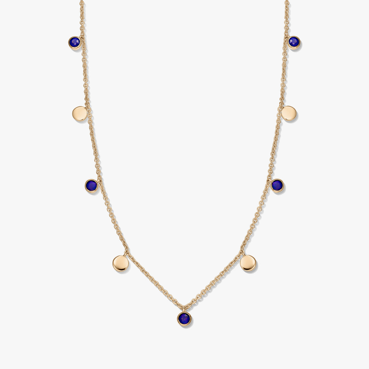 Gold‑plated sterling silver station necklace with round lapis lazuli cabochons and small gold disc charms on a delicate chain, photographed on a white background.