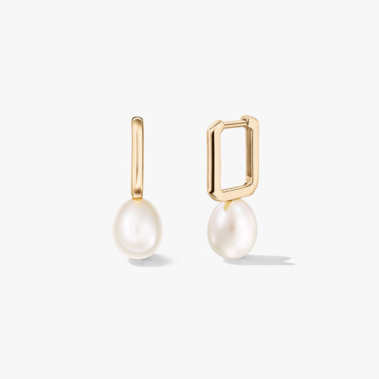 Gold-plated sterling silver huggie earrings with natural white pearl drops; one earring is open to show the rectangular clasp, on a white background.