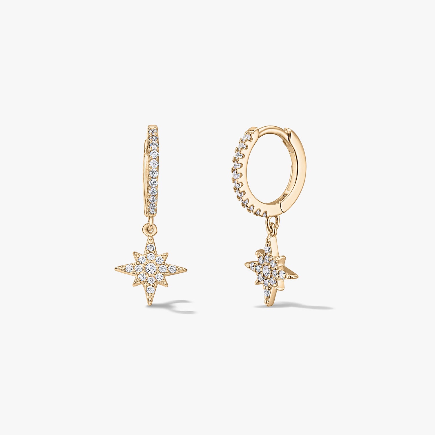 Pair of gold-plated silver huggie hoop earrings with pavé zirconia starburst charms on a white background.