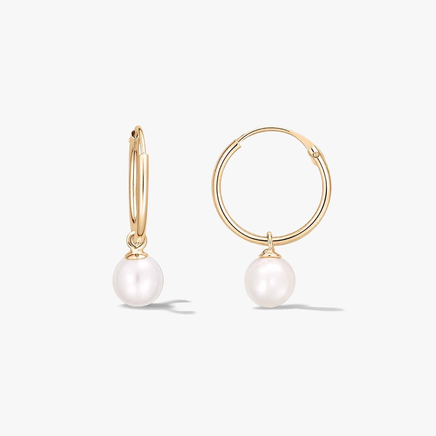 Elegant yellow gold hoop earrings with round natural white pearl drops on a white background.
