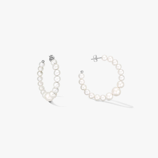 Pair of sterling-silver hoop earrings strung with graduated natural white pearls, shown on a white background.
