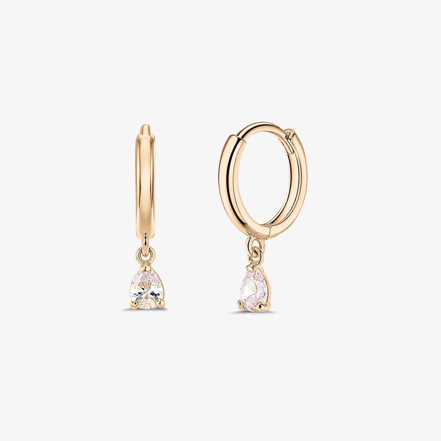 Pair of 14K yellow gold huggie hoop earrings with dangling pear-cut white zirconia drops on a white background.