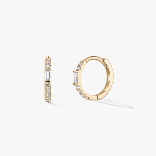 Pair of gold huggie hoop earrings with clear zirconia pavé and a vertical baguette accent, displayed on a white background.
