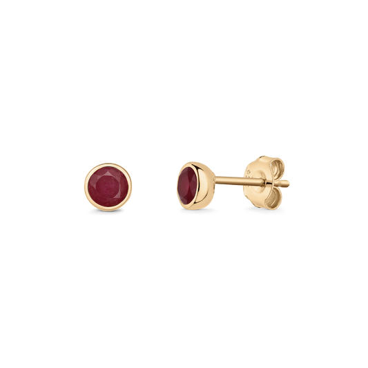 Pair of silver stud earrings featuring round ruby birthstones set in gold-tone bezels with butterfly backs, shown on a transparent background.