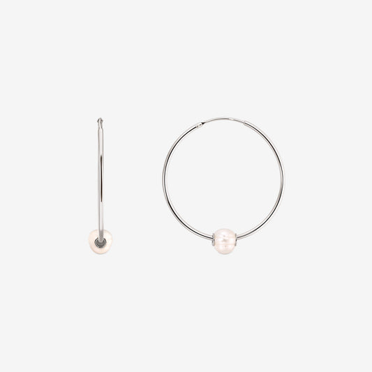 Pair of sterling silver hoop earrings each adorned with a single white cultured pearl, displayed on a white background with one earring shown from the front and the other from the side.
