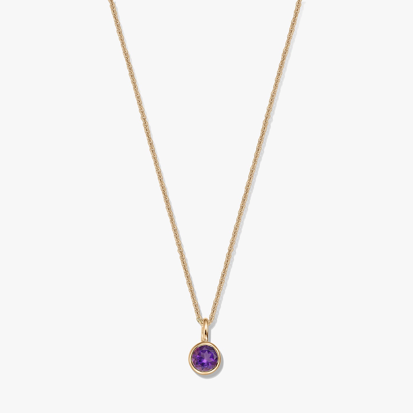 Gold-plated sterling silver necklace with a small round amethyst birthstone pendant on a white background.