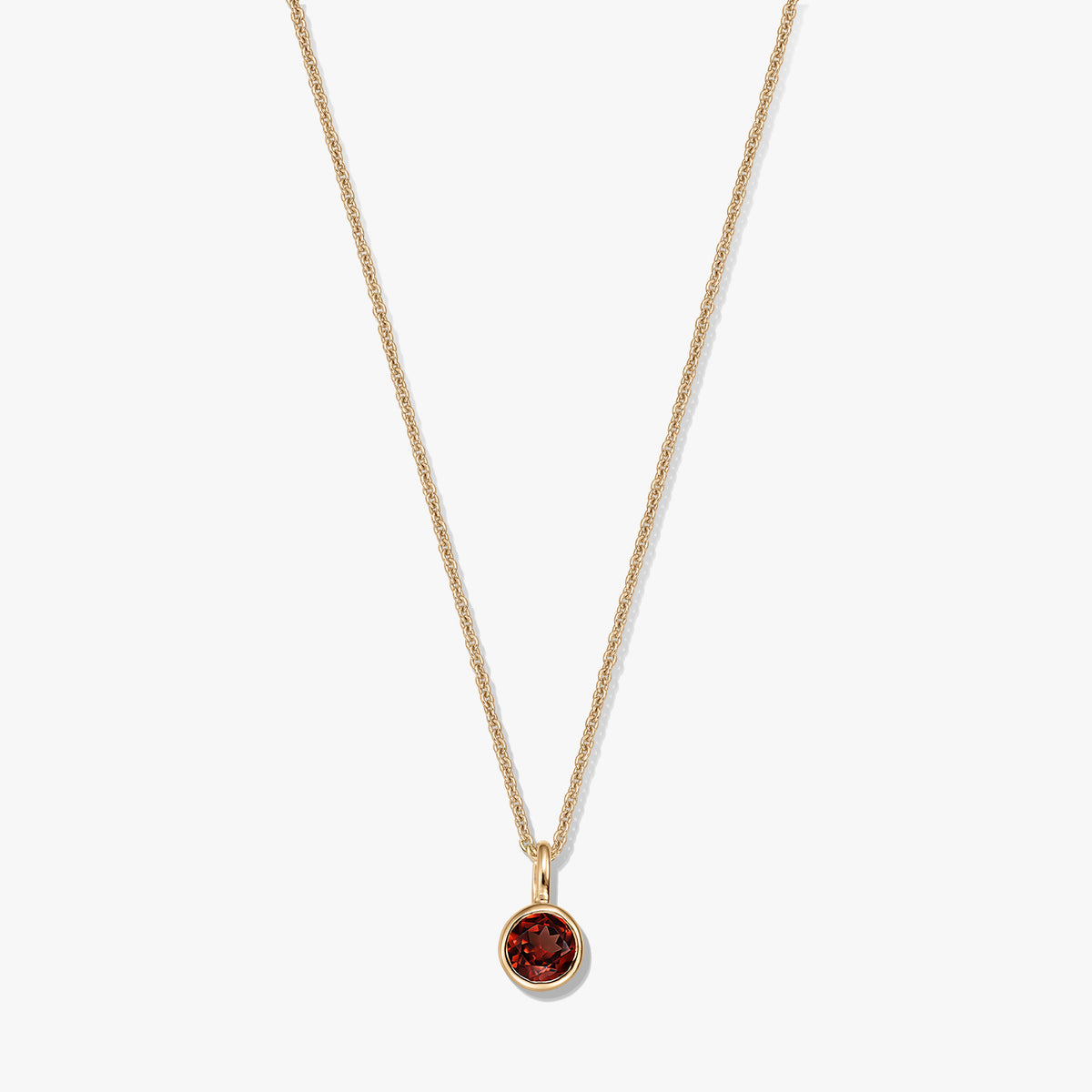 Gold-plated sterling silver birthstone necklace featuring a round bezel-set garnet pendant on a delicate chain, isolated on a white background.