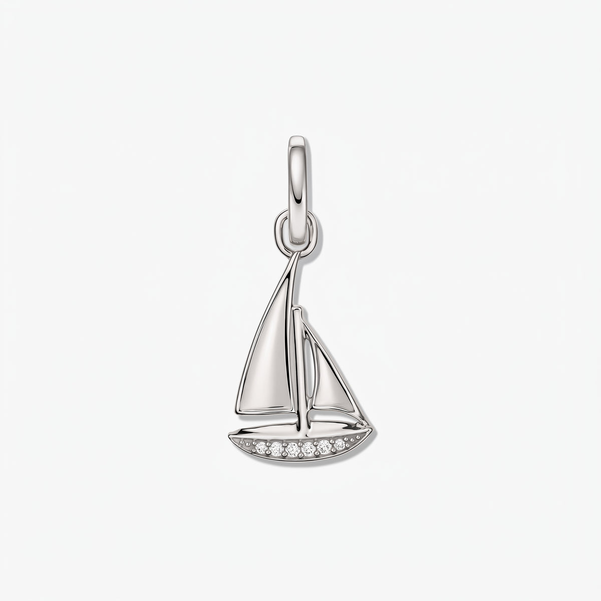 Sterling silver sailboat pendant with small white zirconia accents on a white background.
