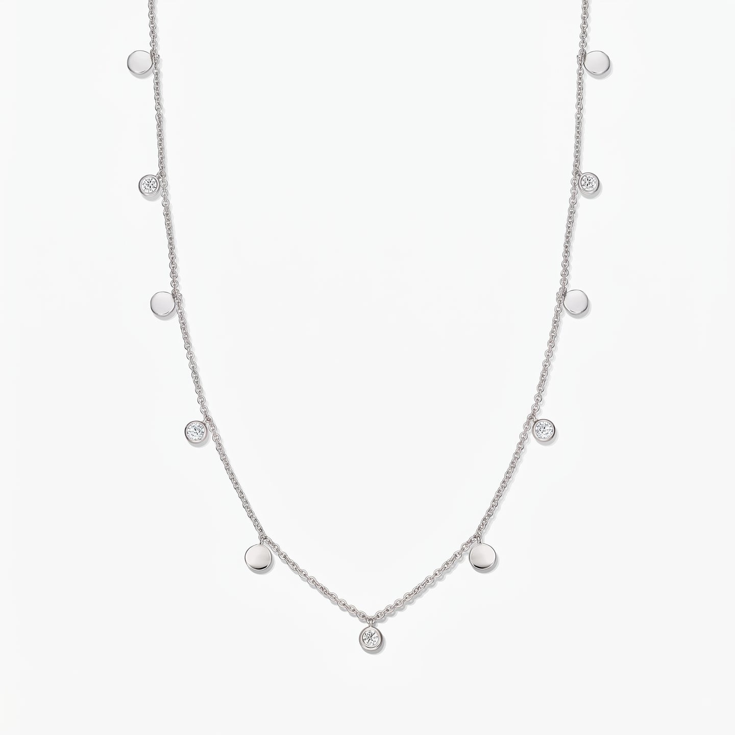 Sterling silver Noora station necklace with alternating polished discs and bezel‑set white topaz stones on a white background.