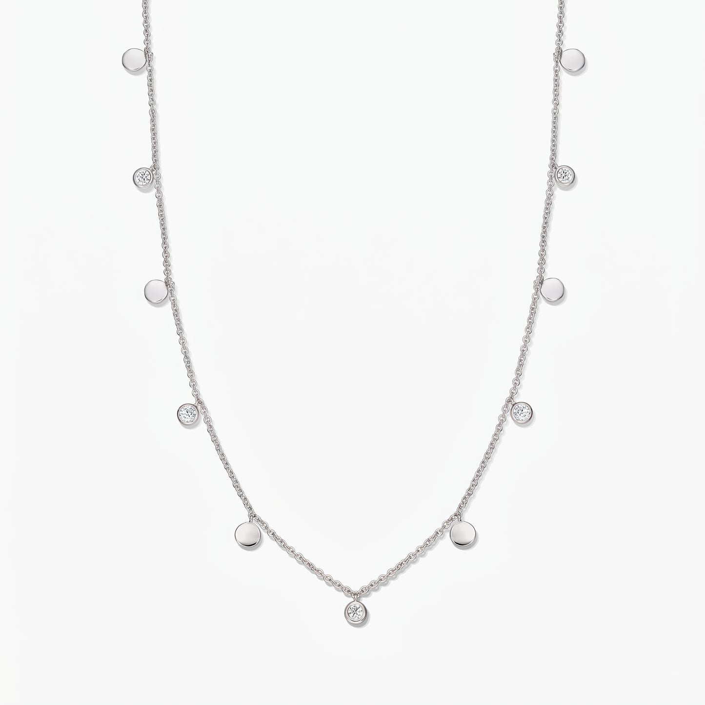 Sterling silver Noora station necklace with alternating polished discs and bezel‑set white topaz stones on a white background.