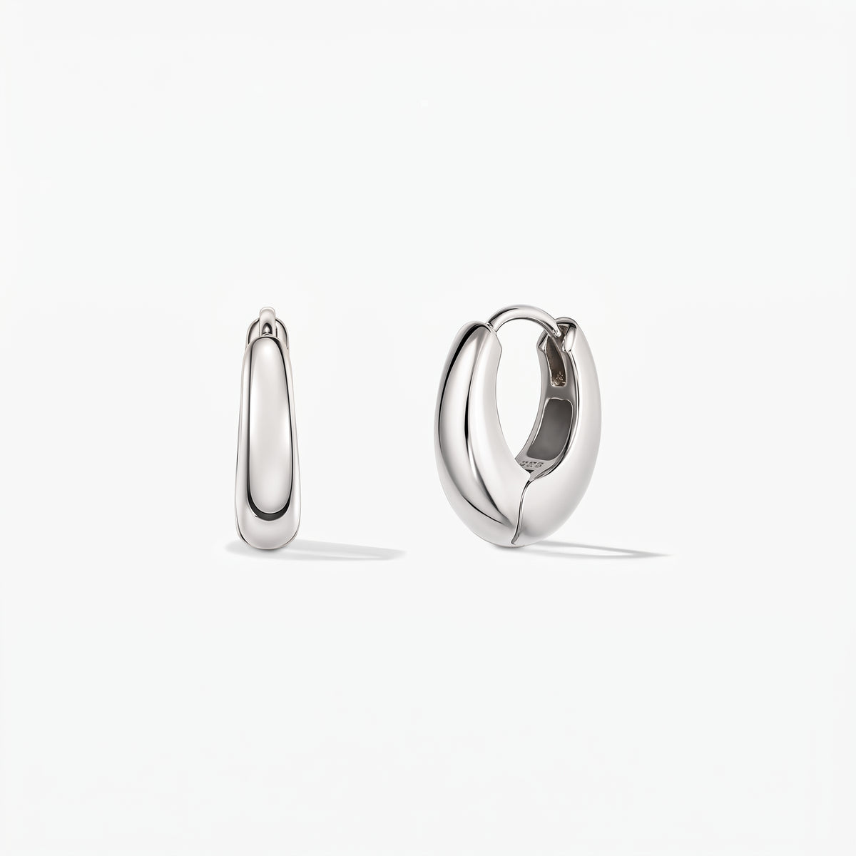 Pair of polished mini-dome silver huggie hoop earrings on a white background, front view, with one open to show the hinged clasp.
