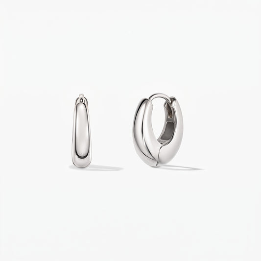 Pair of polished mini-dome silver huggie hoop earrings on a white background, front view, with one open to show the hinged clasp.
