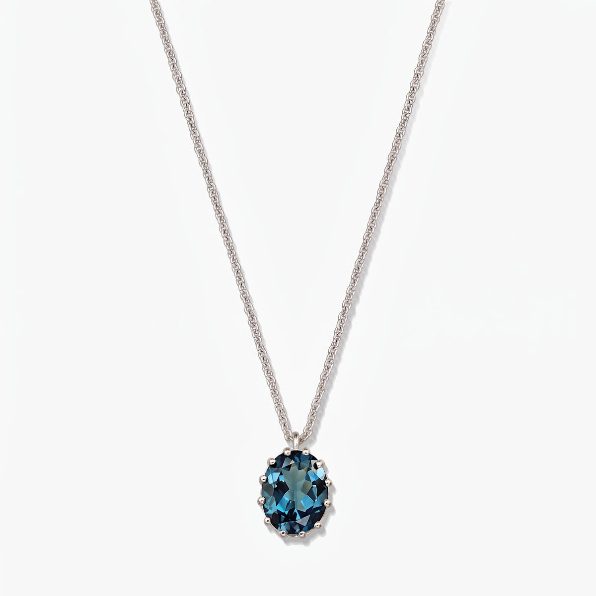 Elegant sterling silver necklace featuring an oval London blue topaz pendant on a white background.