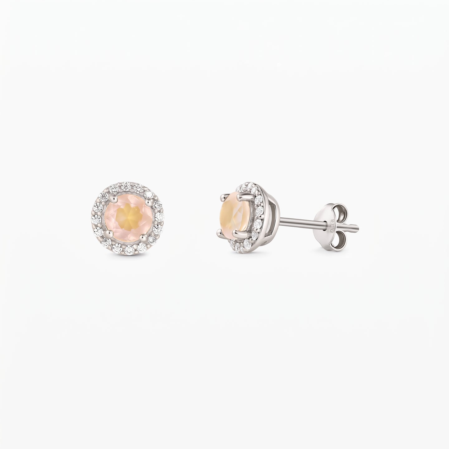Pair of sterling silver stud earrings with round rose quartz centers and a zirconia halo, shown front and side on a white background.