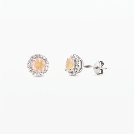 Pair of sterling silver stud earrings with round rose quartz centers and a zirconia halo, shown front and side on a white background.