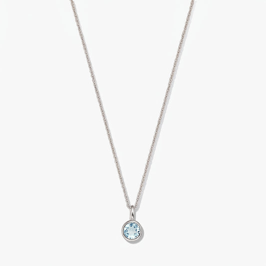 Sterling silver birthstone necklace with a small round bezel-set blue topaz pendant on a white background.