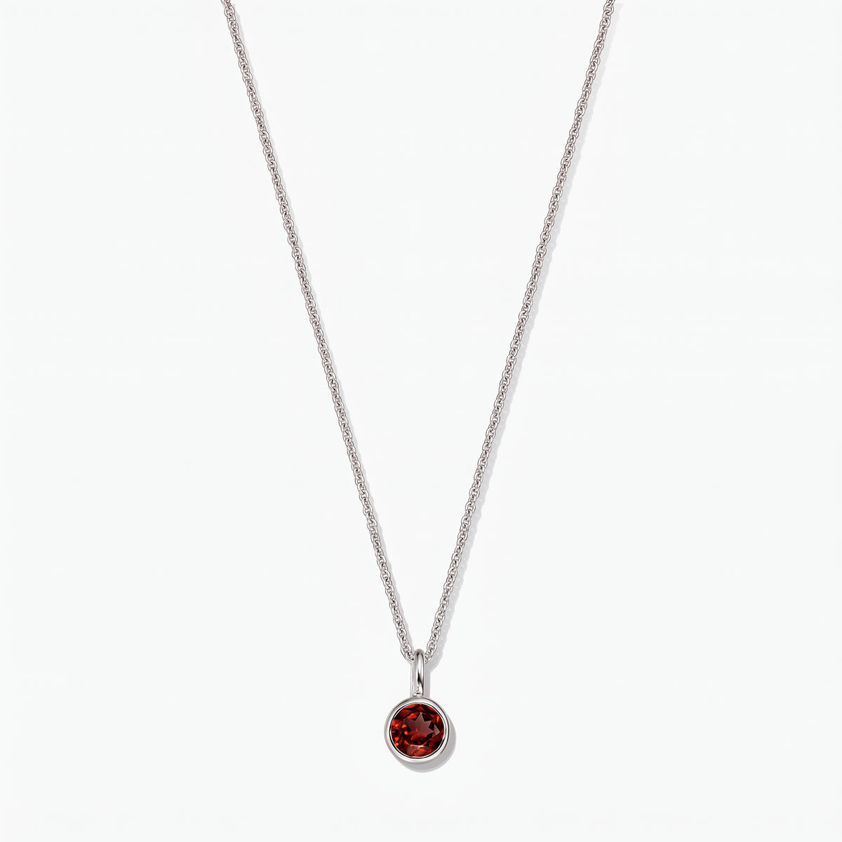 Sterling silver birthstone necklace featuring a round bezel-set garnet pendant on a white background.