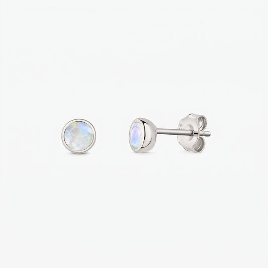Pair of 925 sterling silver moonstone stud earrings on a white background, shown front and side with butterfly backs and bezel-set round iridescent stones.