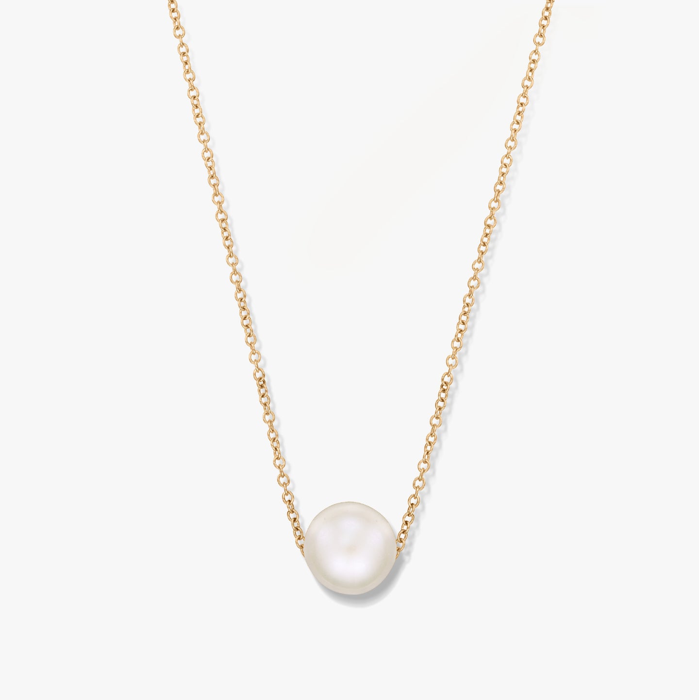 A gold necklace with a single pearl pendant on a white background.